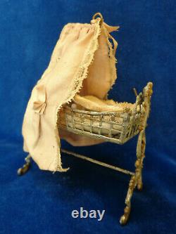 Antique dollhouse cradle with canopy and baby doll dated 1880