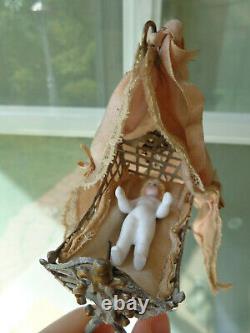 Antique dollhouse cradle with canopy and baby doll dated 1880